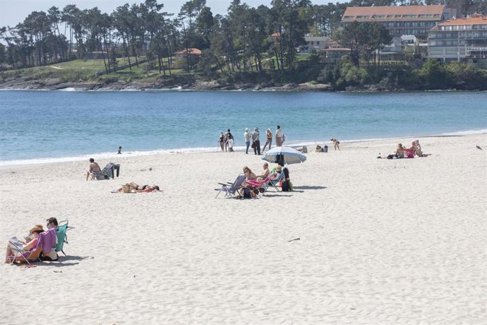 Varias personas en la playa de Sanxenxo, en Pontevedra, Galicia (España), a 27 de marzo de 2021. El subcomité clínico mantiene el nivel alto de restricciones en el concello de Sanxenxo, lo que conlleva que la hostelería solo puede servir en las terrazas