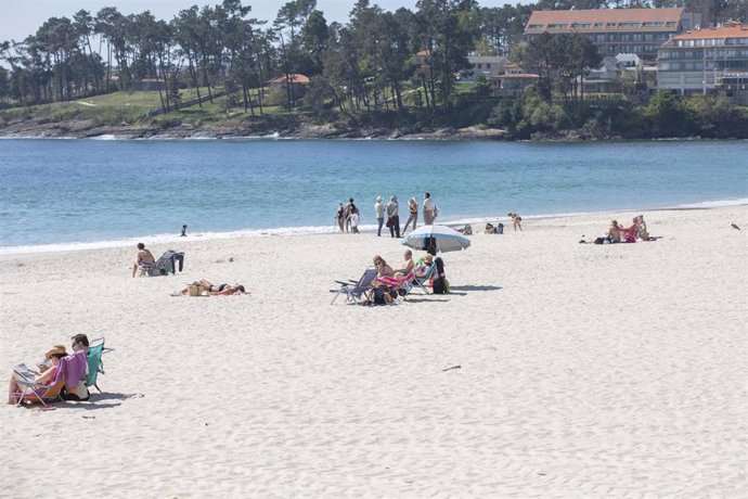 Varias personas en la playa de Sanxenxo, en Pontevedra, Galicia (España), a 27 de marzo de 2021. El subcomité clínico mantiene el nivel alto de restricciones en el concello de Sanxenxo, lo que conlleva que la hostelería solo puede servir en las terrazas