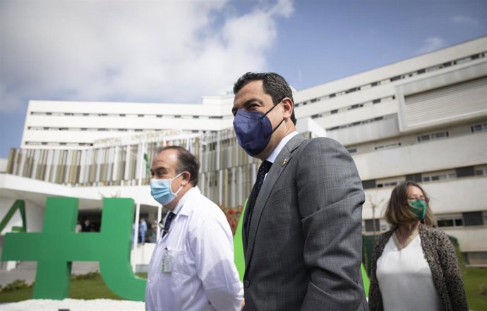 El presidente de la Junta de Andalucía, Juanma Moreno (c) junto un miembro del personal sanitario, durante la visita a las nuevas dependencias del Hospital Universitario Virgen Macarena de Sevilla, (Andalucía, España), a 05 de marzo de 2021.