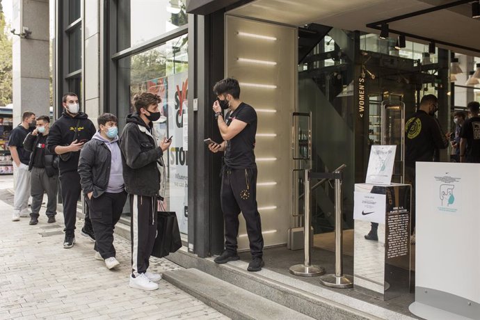 05 April 2021, Greece, Athens: Men wait in line outside a store before its reopning as Greece relaxes some of its coronavirus restrictions. Photo: Socrates Baltagiannis/dpa