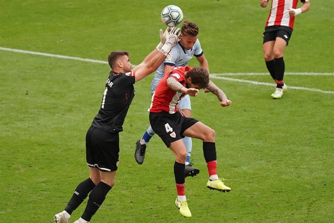 Archivo - Unai Simon intenta despejar un balón entre Llorente e Íñigo Martínez en el Athletic-Atlético de LaLiga Santander 2019-2020