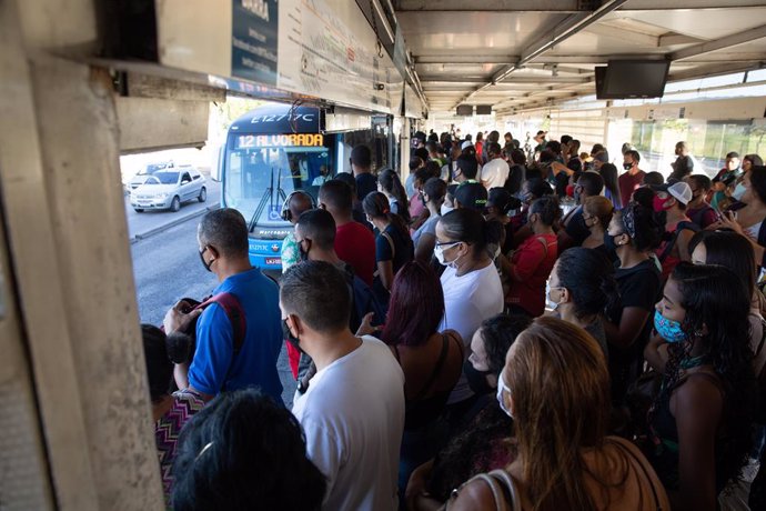 01 April 2021, Brazil, Rio de Janeiro: Passengers wait at a Bus Rapid Transit (BRT) bus stop. Rio De Janeiro is currently under tightened measures against the spread of the coronavirus (Covid-19). A total of 321,515 people have died in Brazil in connect
