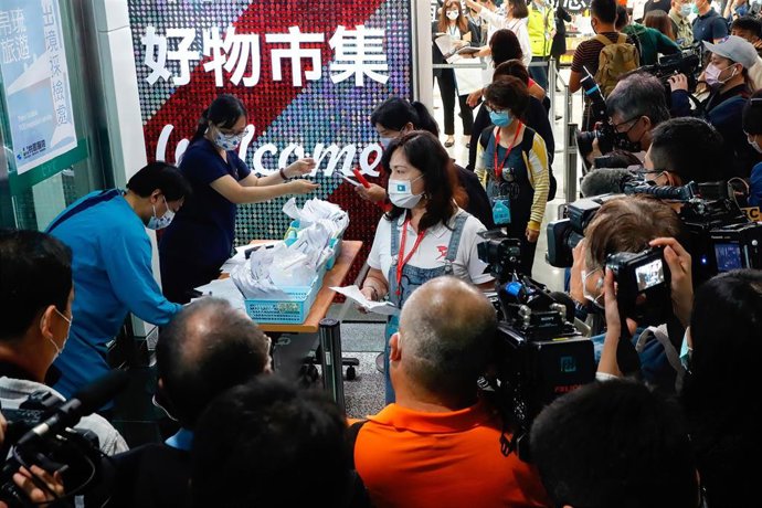 Trabajadores de la salud recolectan pruebas de coronavirus de los viajeros en el aeropuerto de Taoyuan.