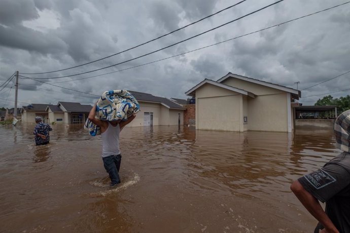 29 March 2021, Indonesia, Pekanbaru: Residents salvage belongings after floodwaters submerged their homes following heavy rains. Photo: Afrianto Silalahi/ZUMA Wire/dpa
