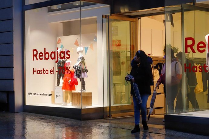 Archivo - Una mujer sale de un comercio 