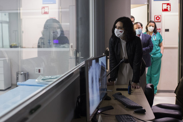 La presidenta de la Comunidad de Madrid, Isabel Díaz Ayuso, observa a una habitación durante su visita al Complejo Hospitalario 12 de Octubre