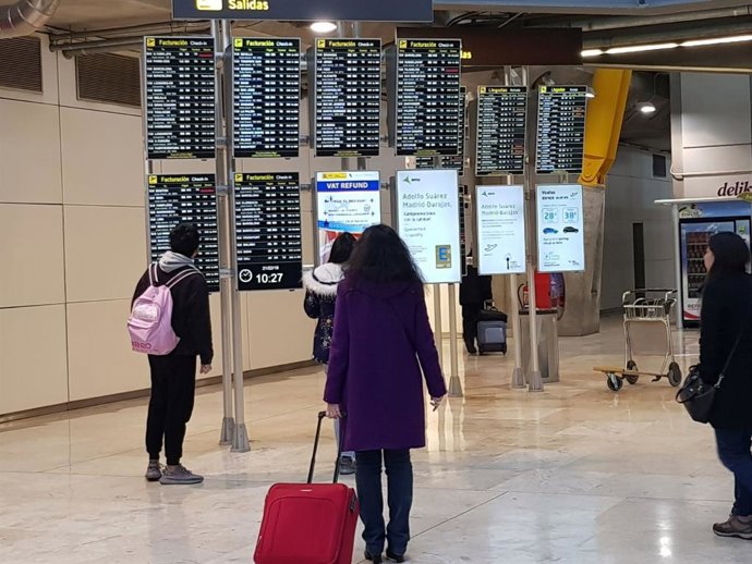 Archivo - Pasajeros en paneles del aeropuerto de Madrid- Barajas (España).