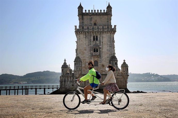 Personas en bicicleta ante la Torre de Belem en Lisboa