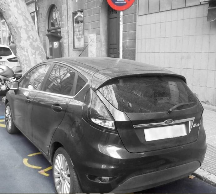 Archivo - Coche estacionado en una plaza para personas con discapacidad