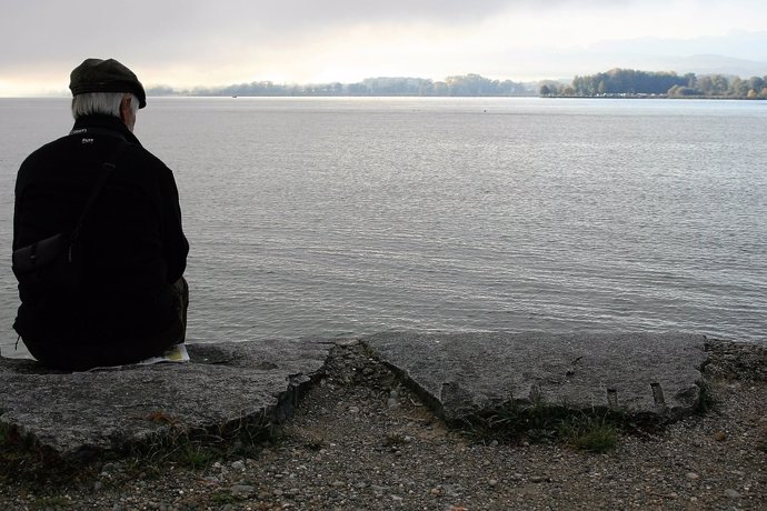 Archivo - Un hombre sentado frente a un lago.