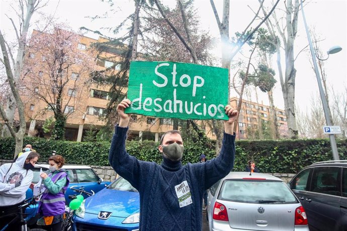 Archivo - Un hombre con un cartel en el que se lee: `Stop desahucios durante una manifestación por el derecho a la Vivienda, frente a la sede de la SAREB, en Madrid (España), a 21 de febrero de 2021.