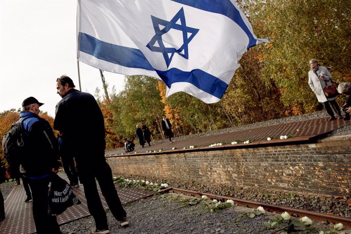 Archivo - Un hombre con una bandera de Israel en conmemoración del aniversario del Holocausto.