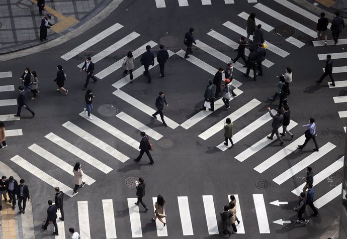 26 March 2021, South Korea, Seoul: Pedestrians cross a zebra intersection in Seoul. The South Korean government decided on Friday to extend ongoing second-level social distancing rules that were originally set to expire on 28 March 2021, including a ban
