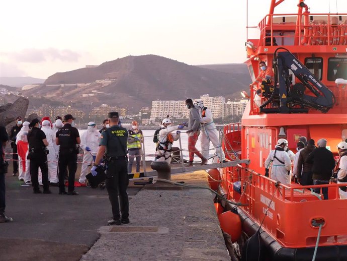 MIembros de la Cruz Roja ayudan a bajar del barco a migrantes en el puerto de Arguineguín (Gran Canaria)
