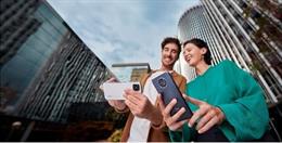 Un joven enseña algo en su telefóno a una joven.