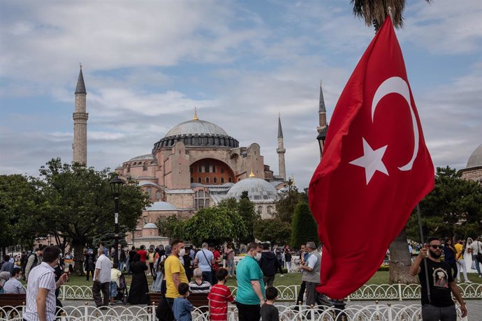 Archivo - Un hombre agita la bandera nacional de Turquía frente a la Mezquita de Santa Sofía en el cuarto aniversario del fallido intento de golpe del 15 de julio de 2016.
