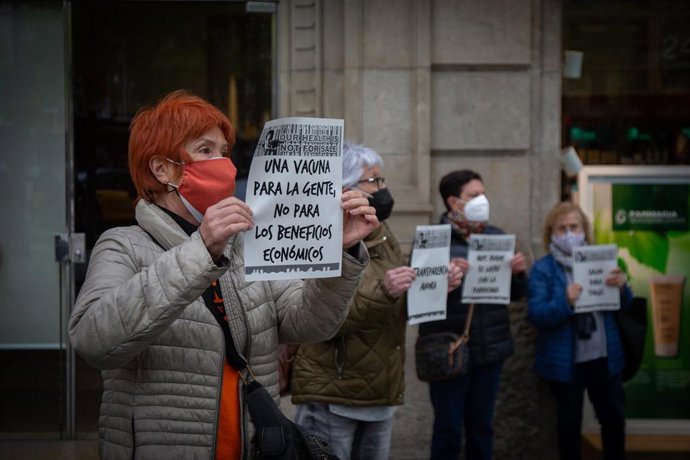 Una mujer sostiene un cartel reclamando un acceso igualitario a las vacunas contra el Covid-19, ante la delegación de la Comisión Europea en Barcelona, situada en el Paseo de Grcia, este miércoles 7 de abril del 2021.