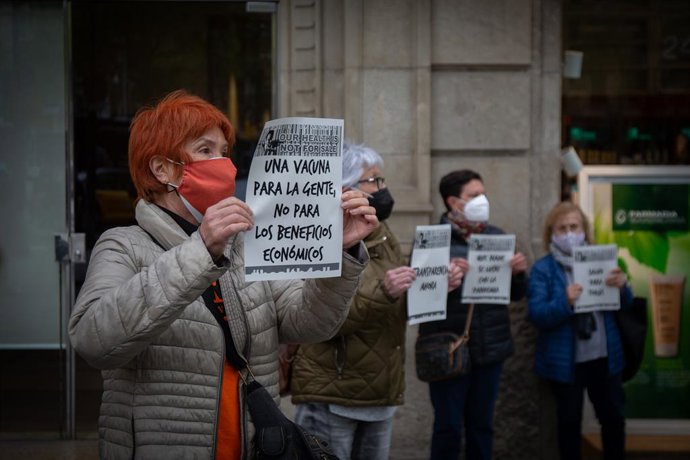 Una mujer sostiene un cartel reclamando un acceso igualitario a las vacunas contra el Covid-19, ante la delegación de la Comisión Europea en Barcelona, situada en el Paseo de Grcia, este miércoles 7 de abril del 2021.