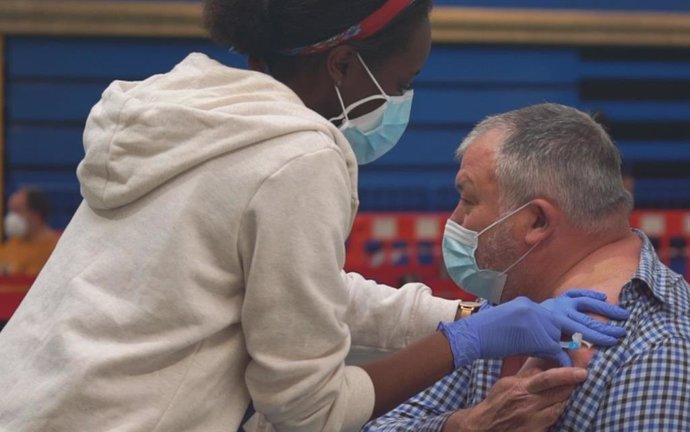 Una trabajadora sanitaria administra a un hombre la vacuna contra la COVID-19 en el polideportivo Germans Escalas, en Palma.