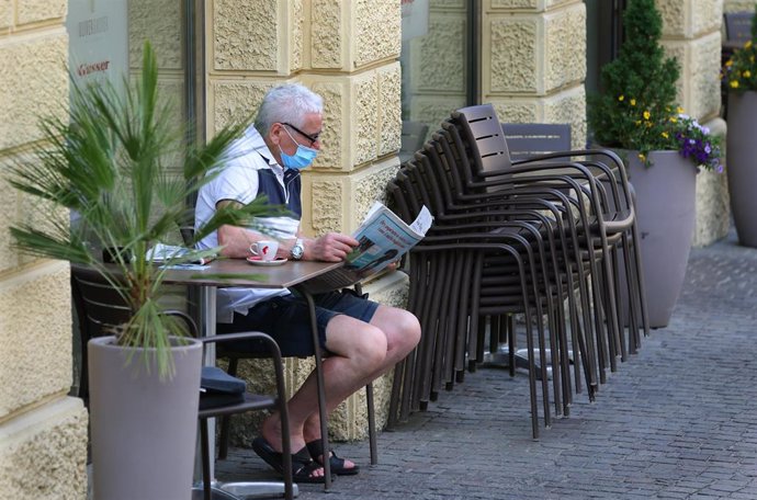 Archivo - Un hombre con mascarilla lee un periódico durante la pandemia de coronavirus en Italia