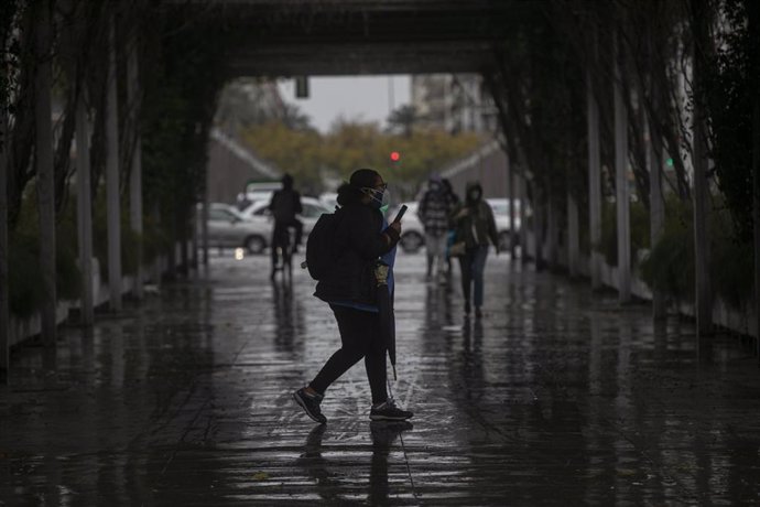 Archivo - Peatones con paraguas durante un día lluvioso y con rachas de viento en la provincia. En Sevilla (Andalucía, España), a 09 de febrero de 2021.
