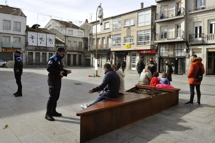 Archivo - Agentes de la Policía Local de Xinzo de Limia y vecinos en la plaza Mayor adornada con el "Meco" tradicional de Entroido gallego, en Xinzo de Limia, perteneciente al 'Triángulo Mágico' en Ourense, Galicia (España), a 14 de febrero de 2021. El 