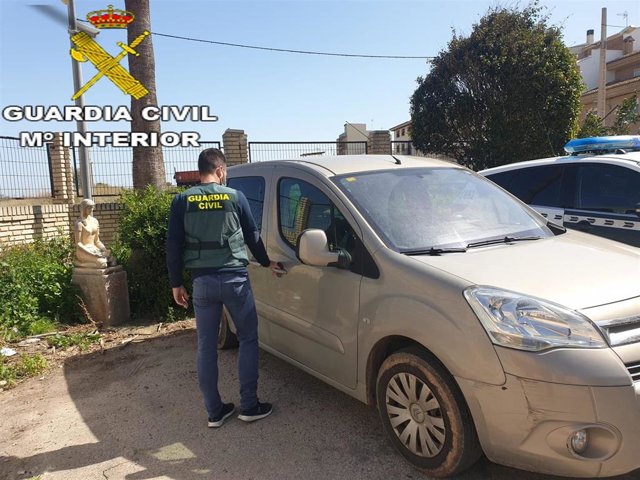 Un agente junto a un vehículo