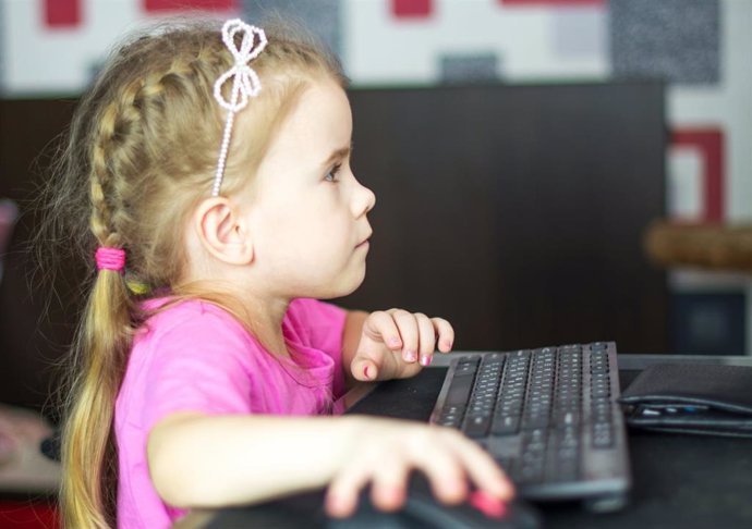 Una niña utilizando un ordenador de sobremesa