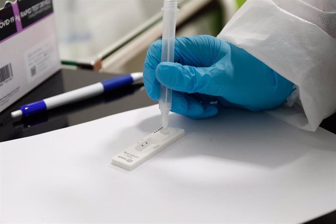 Una trabajadora sanitaria sostiene un test de antígenos