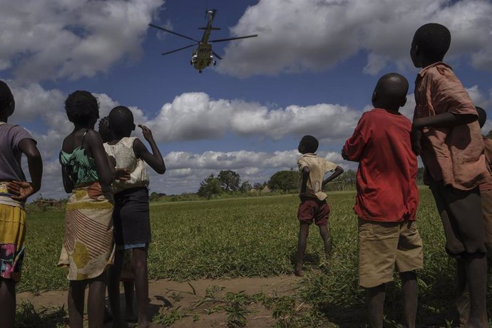 Archivo - Un grupo de niños observa un helicóptero en Mozambique