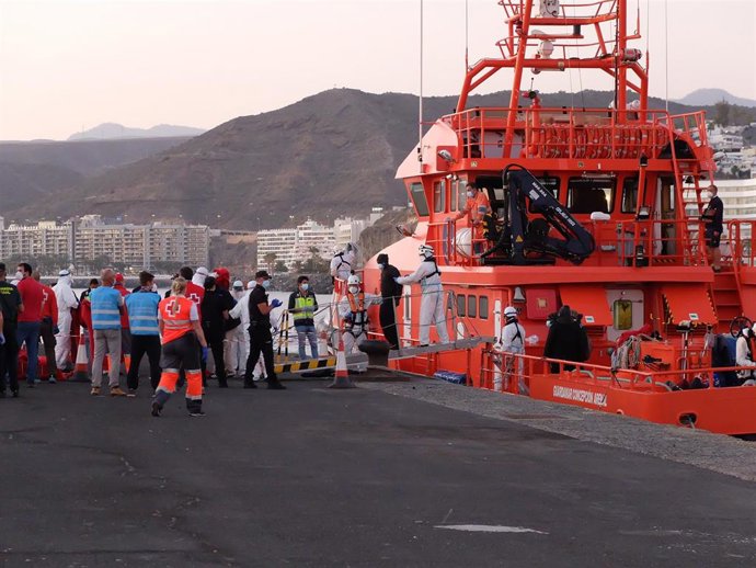 MIembros de la Cruz Roja ayudan a bajar del barco a migrantes en el puerto de Arguineguín (Gran Canaria)