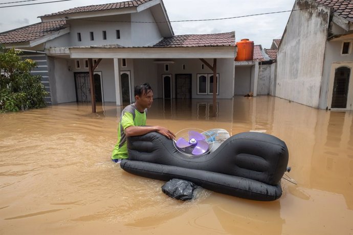 Residentes de Pekanbaru intentan salvar sus pertenencias tras un fuerte ciclón.