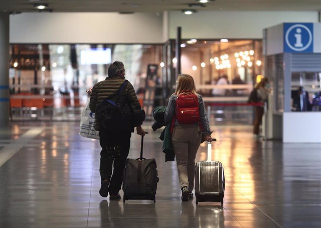 Dos pasajeros caminan por la Estación de Méndez Álvaro, en Madrid (España), a 26 de marzo de 2021. Un total de 4.818 efectivos de las Fuerzas y Cuerpos de Seguridad del Estado (FCSE) se están desplegando esta Semana Santa en la Comunidad de Madrid para 