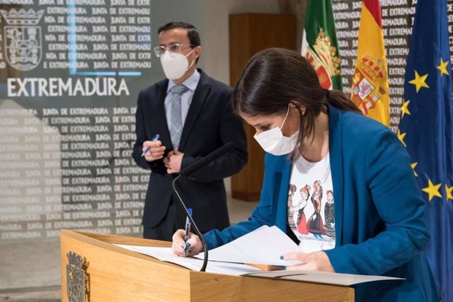 Isabel Gil Rosiña firma, con Miguel Ángel Gallardo al fondo, el protocolo entre la Aexcid y Felcode.