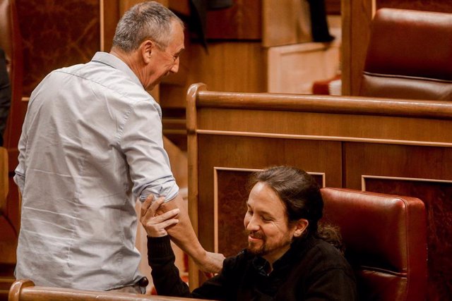 Archivo - El secretario general de Podemos, Pablo Iglesias (dcha) cogiendo del brazo (entre risas) al portavoz parlamentario de Compromís, Joan Baldoví (izq) en el primer pleno ordinario en el Congreso de los Diputados desde el pasado mes de julio