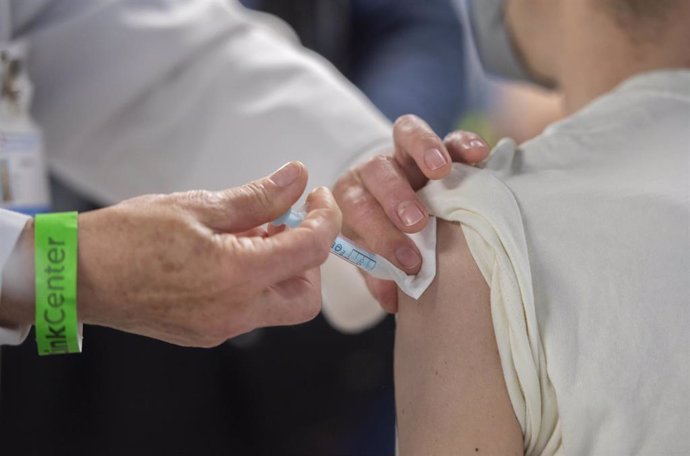 Una trabajadora sanitaria administra la primera dosis de la vacuna AstraZeneca contra el Covid-19 a una persona en el Wizink Center, a 9 de abril de 2021, en Madrid, (España). El dispositivo, puesto en marcha este viernes por la Comunidad de Madrid y co