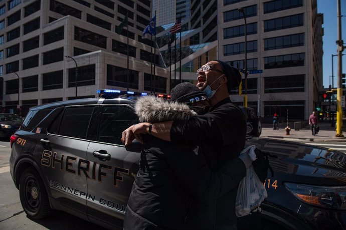 02 April 2021, US, Minneapolis: Protesters cry while police officers removing the photos and locks from the fencing outside the Hennepin County Courthouse, where the trial of a former Minneapolis police officer Derek Chauvin in the death of George Floyd