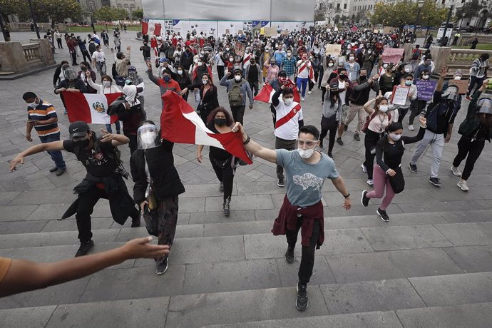 Archivo - 10 November 2020, Peru, Lima: People hold Peruvian national flags during a protest at Plaza San Martin against the removal of President Martin Vizcarra. Photo: Alex Rosemberg/dpa