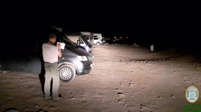 Un agente de Medio Ambiente impone una multa a vehículos por estacionamiento prohibido en el Parque de Cabo de Gata-Níjar (Almería)