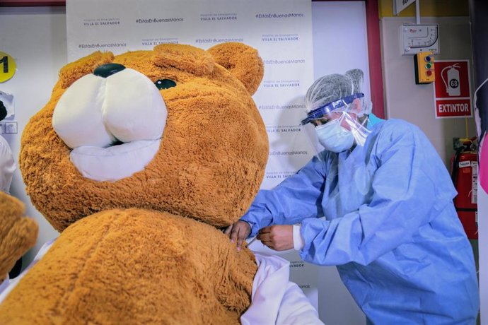 Archivo - Una persona disfrazada de oso de peluche recibe simbólicamente la vacuna del coronavirus en Lima, Perú