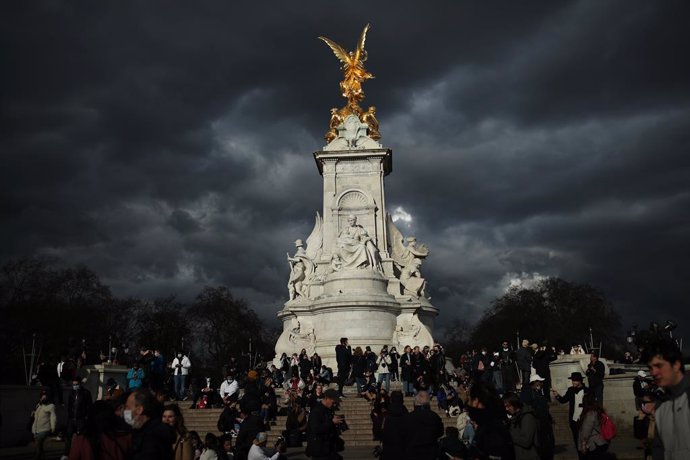 09 April 2021, United Kingdom, London: People stand  outside Buckingham Palace, following the announcement of the death of the Duke of Edinburgh at the age of 99. Photo: Yui Mok/PA Wire/dpa