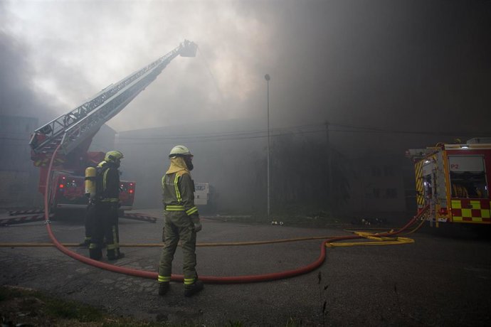 Bomberos trabajan en la extinción de un incendio en el Polígono Industrial Ceao, a 11 de abril de 2021, en Lugo, Galicia (España). El voraz incendio iniciado en la mañana de este domingo en el Polígono de O Ceao, en Lugo, ha quedado controlado pasado el