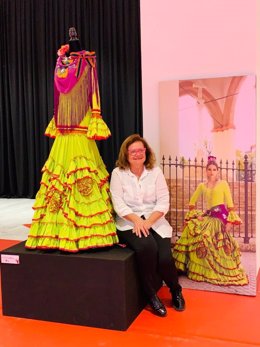 La diseñadora Pilar Vera, presidenta de la asociación Mof&Art, posa con uno de sus diseños en la exposición sobre moda flamenca, del centro comercial Los Arcos.