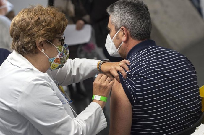 Una trabajadora sanitaria administra la primera dosis de la vacuna AstraZeneca contra el Covid-19 a una persona en el Wizink Center, a 9 de abril de 2021, en Madrid, (España).