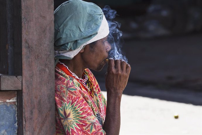 Una mujer fumando en un mercado local de Wamena, provincia de Papua, en Indonesia.