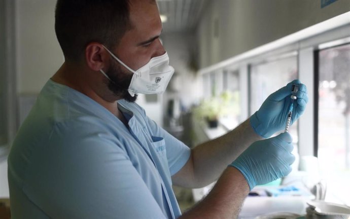 Un sanitario prepara una de las dosis de la vacuna Pzifer antes de suministrarsela a un anciano, en el Hospital Universitario de La Paz, a 12 de abril de 2021, en Madrid (España). La Paz es uno de los diez hospitales de la red pública madrileña que la C