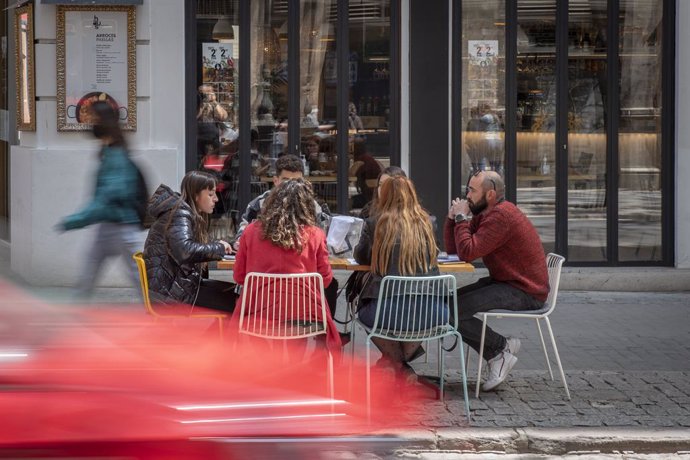 Seis personas sentadas en una terraza el día en que se amplían a seis los comensales por mesa, a 12 de abril de 2021, en Valencia, Comunidad Valenciana (España).