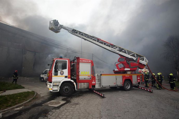 Un bombero trabaja en la extinción de un incendio en el Polígono Industrial Ceao, a 11 de abril de 2021, en Lugo, Galicia (España). 