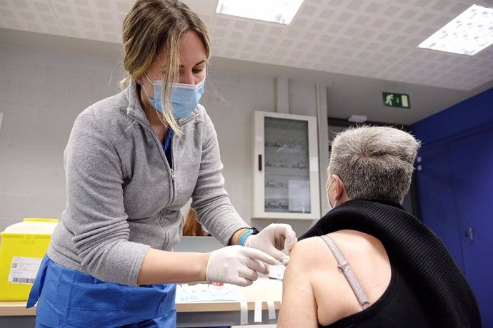 Una sanitria vacuna a una dona a Catalunya, el dia en el qual es reprn la vacunació amb AstraZeneca.