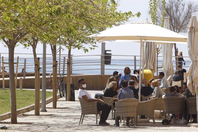 Varias personas en la terraza de un bar, a 11 de abril de 2021, en Mallorca, Islas Baleares (España). Este domingo ha comenzado la prórroga del cierre del interior de bares y restaurantes en Mallorca. La medida se ha prorrogado justo cuando terminan las